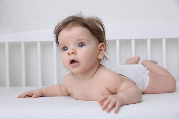 Cute little baby lying in comfortable crib at home - Foto, Imagen
