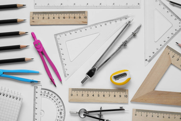 Flat lay composition with different rulers and compass on white background - Foto, immagini