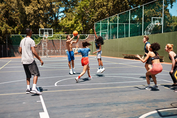 Суд на засіданні. група спортивної молоді, яка грає в баскетбол на спортивному майданчику
 - Фото, зображення
