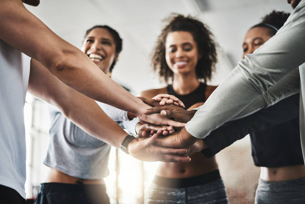 Fitness can be contagious. a group of young people joining their hands together in solidarity at a gym - Fotoğraf, Görsel