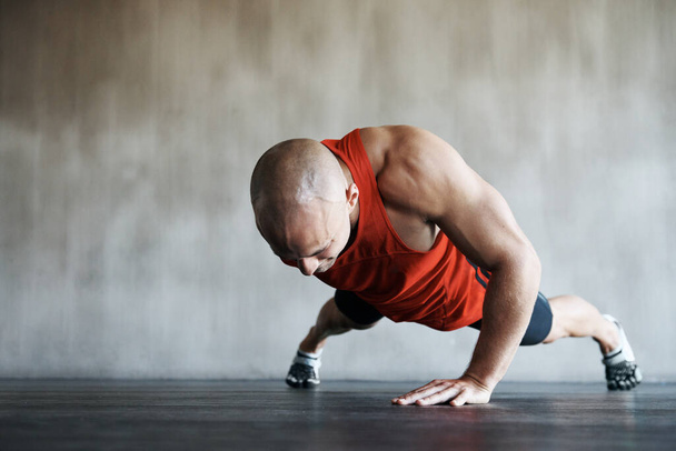 Gym, man and one arm push up for exercise performance, workout determination and sports training focus. Athlete discipline, strength endurance mockup or active male person concentrate on floor pushup. - Foto, Imagen