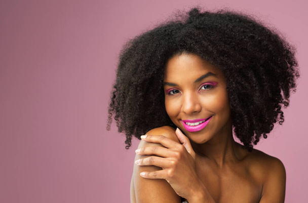 Hair care, face and smile of black woman with makeup in studio isolated on a pink background mockup for skincare. Hairstyle portrait, cosmetics and African female model with salon treatment for afro - Foto, Imagem
