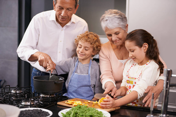 Aide, enfants heureux ou grands-parents enseigner les compétences culinaires pour un dîner sain avec des légumes régime à la maison. Apprendre, enfants frères et sœurs aider ou grand-mère avec vieil homme ou repas dans la cuisine. - Photo, image