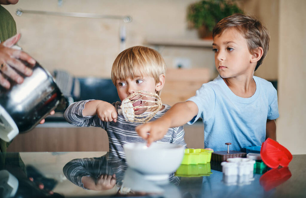 Assaggiatori ufficiali di pastella in servizio. due adorabili bambini che cucinano insieme a casa - Foto, immagini