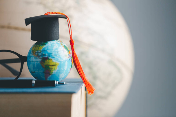 Graduation cap with Earth globe. Concept of global business study, abroad educational, Back to School. Education in Global world, Study abroad business in universities in worldwide. language study - Photo, Image