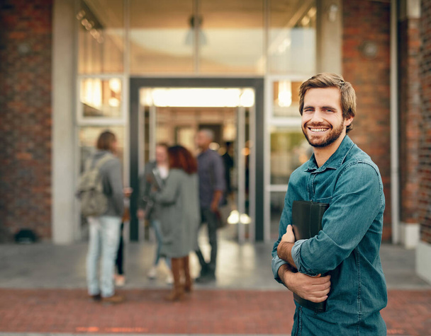 Investieren in meine Zukunft. Porträt eines glücklichen jungen Mannes, der draußen auf dem Campus steht - Foto, Bild
