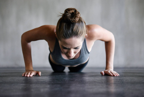 Training, push up and woman on a floor for fitness, cardio and endurance at gym. Plank, exercise and female athlete at a health center for core, strength and ground workout with determined mindset. - Photo, Image