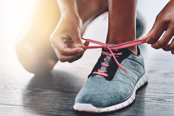 Schuhe, Nahaufnahme und Schnürsenkel, um in einem Fitnessstudio mit Bewegung, Workout oder Wellness-Sport zu beginnen. Turnschuhe, Sport und Hände einer gesunden Frau oder Läuferin bereit für das Training. - Foto, Bild