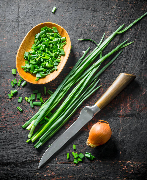 Onions and green onions. On dark rustic background - Foto, afbeelding