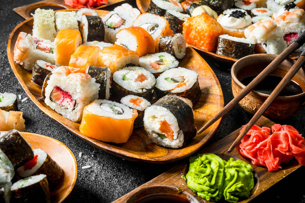 Pieces of delicious sushi, rolls and maki. On rustic background - Фото, зображення