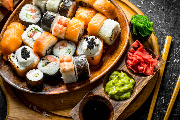 Assorted different types of Japanese sushi and rolls. On dark rustic background - Foto, Bild