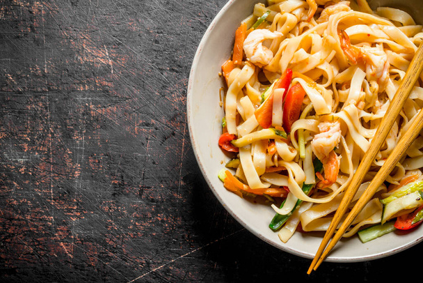 Noodles with shrimp and vegetables. On dark rustic background - Foto, Imagem