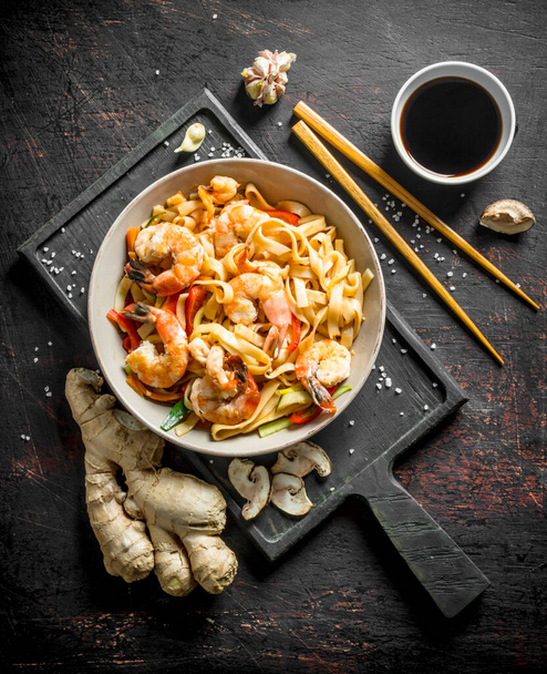 Noodles in a plate on a cutting Board with ginger and soy sauce. On dark rustic background - Foto, Imagen