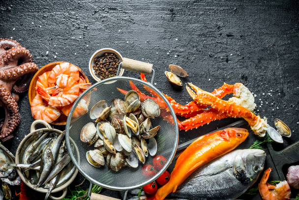 Seafood. Oysters with fresh fish, crab and shrimp. On black rustic background - Valokuva, kuva