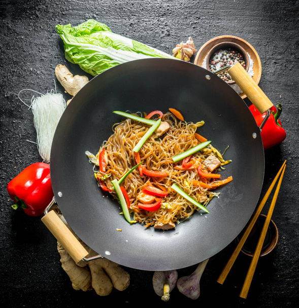 Chinese wok. Ingredients for cooking funchoza with vegetables. On black rustic background - Фото, зображення