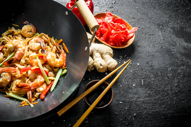 Wok Udon noodles with ginger, soy sauce and bell pepper. On black rustic background - Foto, Bild