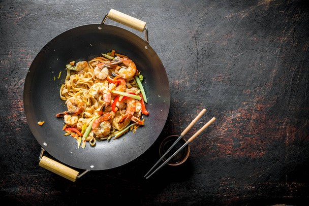 Freshly cooked Asian Udon noodles with vegetables and shrimp. On dark rustic background - Foto, Imagem