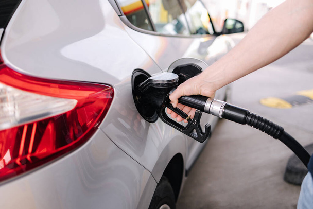 Man refueling the car at a gas station. Close-up of driver hand pumping gasoline car with fuel at the refuel station. High quality photo - Foto, Imagem