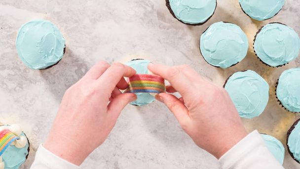 Flat lay. Step by step. Decorating chocolate cupcakes with buttercream frosting and rainbow candy. - Photo, Image