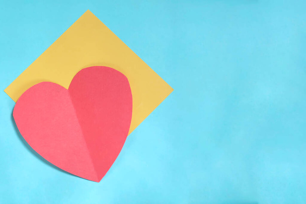 Red paper heart and yellow card on blue backgrounds. Valentines day card with copy space - Photo, image