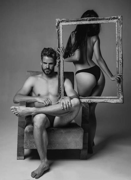 Attractive young couple holding picture frame. Attractive man and woman being playful. Erotic and spiritual feeling. Copy space. Young man and woman. Intimate relationship and sexual relations - Foto, Bild