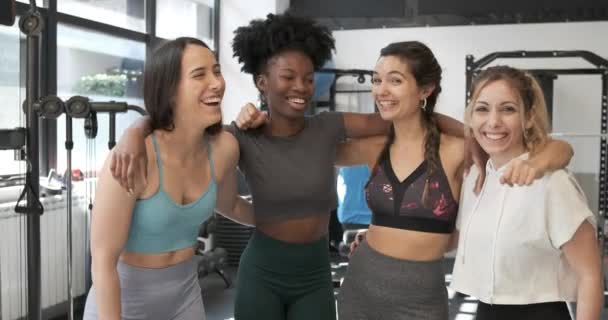 Zeitlupenvideo einer multiethnischen Gruppe von Frauen, die sich in einem Fitnessstudio umarmen und lächeln - Filmmaterial, Video