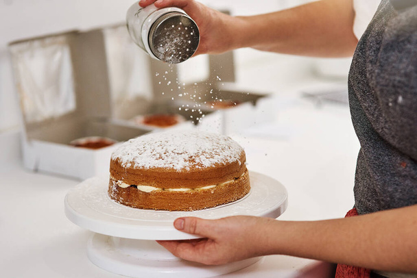 Tule kokemaan ilon maku. nainen koristelu kakku hänen keittiössä - Valokuva, kuva