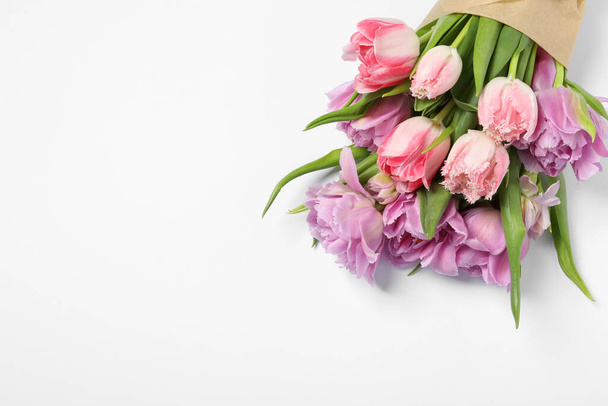 Beautiful bouquet of colorful tulip flowers on white background, top view. Space for text - Fotó, kép
