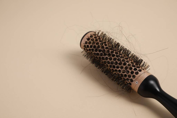 Professional brush with lost hair on beige background, closeup. Space for text - Фото, зображення