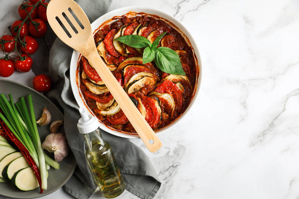 Delicious ratatouille and ingredients on white marble table, flat lay. Space for text - Foto, Imagem
