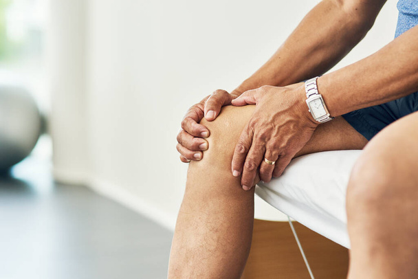 Physiotherapy, knee pain and injury with legs of man in room for consulting, medical and arthritis. Rehabilitation, muscle and joint with closeup of patient in clinic for physical therapy and healing. - Valokuva, kuva