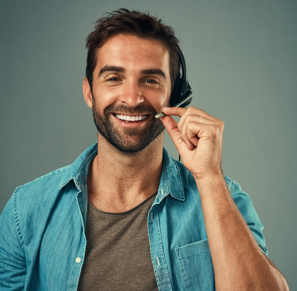 Happy man, headphones and portrait smile of call center consultant against a grey studio background. Face of friendly male consulting agent smiling with headset mic in contact us for online advice. - Fotoğraf, Görsel