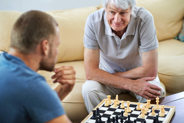 Souviens-toi de ce que je t'ai appris. un père et son fils jouant ensemble à un jeu d'échecs à la maison - Photo, image