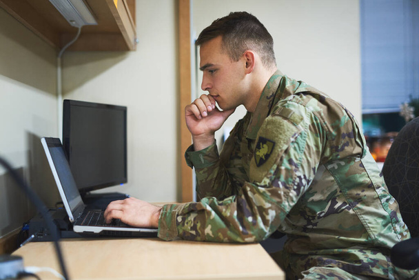 Laptop, thinking and military man with security software, online research and law academy in office. Planning, soldier or young army person on computer, internet search or website information check. - Foto, Imagem