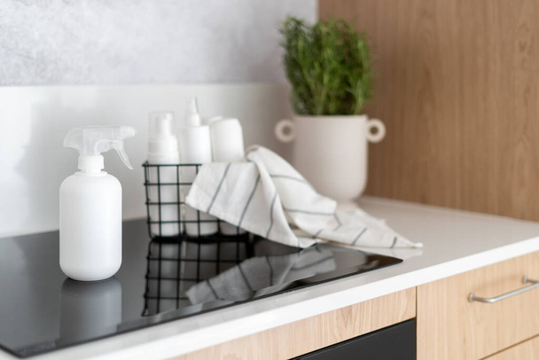 Nahaufnahme einer Kunststoff-Sprühflasche mit Reinigungsmittel zur Reinigung von Induktionsherd und Haushaltsgeräten in der heimischen Küche, Werbekonzept - Foto, Bild