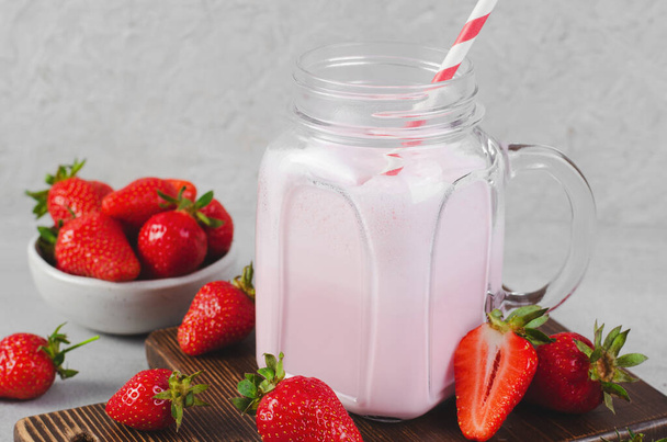 Boisson aux fraises, milkshake à la fraise fraîche sur fond gris clair - Photo, image