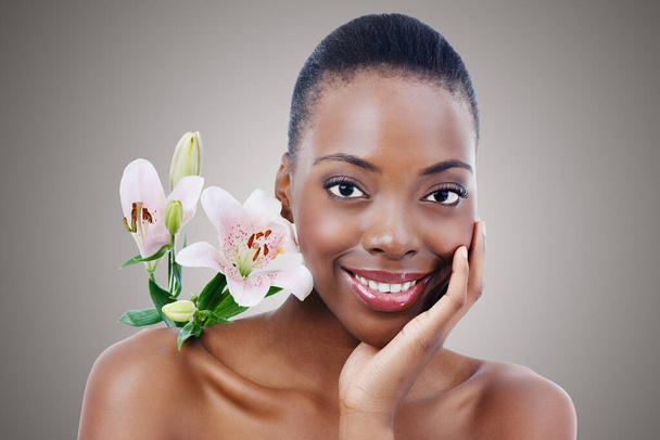 Delicate beauty. A beautiful african woman posing with flowers - closeup - Zdjęcie, obraz