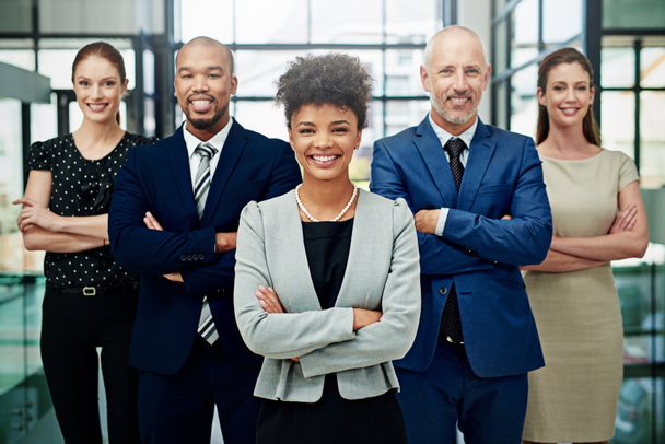 Portrait, diversity and happy business people with arms crossed for professional commitment, pride or teamwork. Group, African woman leader and corporate employees smile for global company unity. - 写真・画像