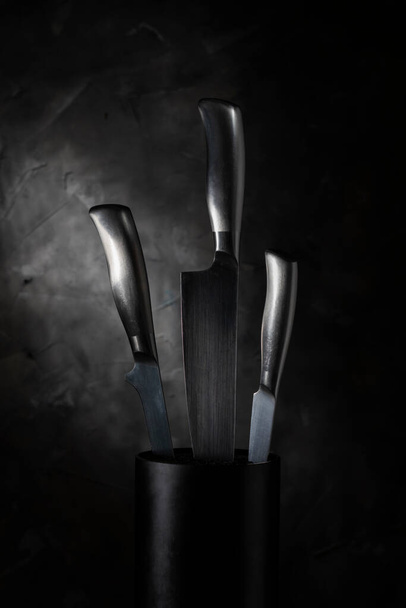 Three metal knives on a blurred wall background - Fotó, kép