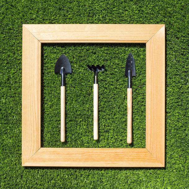 Садові інструменти в рамці на траві
 - Фото, зображення