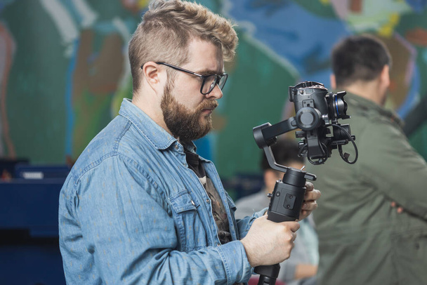 男のビデオメーカーは、イベントにインタビューを記録デジタルディスプレイとニュース会議現代のビデオカメラで動作します。マスメディアとテレビと技術 - 写真・画像