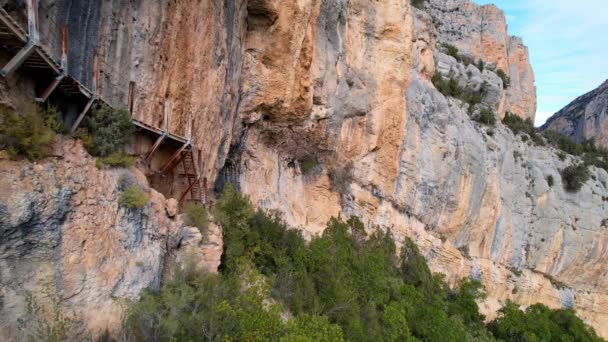 Panoramique belle vue aérienne vertigineuse impressionnante de bas en haut de l'escalier en bois à la falaise rocheuse dans le cadre du sentier de randonnée dans la gorge de Congost de Montrebei en Catalogne dans les Pyrénées, Espagne.Vidéo 4K - Séquence, vidéo