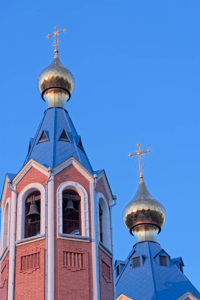 Blue roofs of orthodox church against clear blue sky. Cathedral of Our Lady of Kazan in Komsomolsk-on-Amur in Russia - 写真・画像
