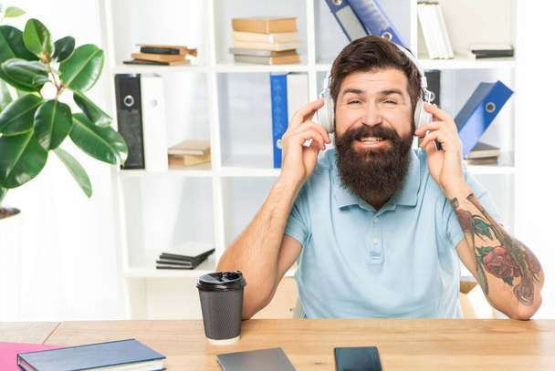 Happy man listening to melody in headphones in office, music. - Foto, imagen