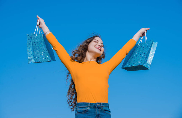 glad teen girl with shopping bags, blue yellow. - Valokuva, kuva