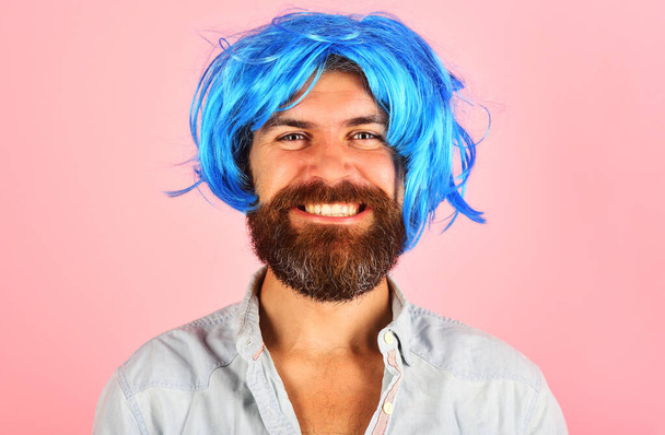 Homme souriant en perruque bleue. Homme heureux avec barbe et moustache en perruque colorée. Un mec élégant aux cheveux bleus. Homme barbu en perruque. Homme en perruque. L'émotion. C'est parti. Publicité de salon de coiffure. Portrait rapproché - Photo, image