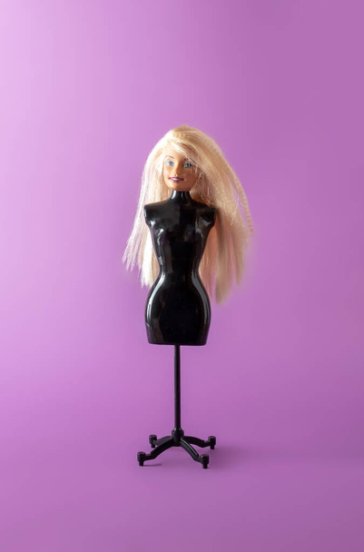 Голова дівчинки ляльки на чорній підставці для ляльки. Мінімальна концепція
. - Фото, зображення
