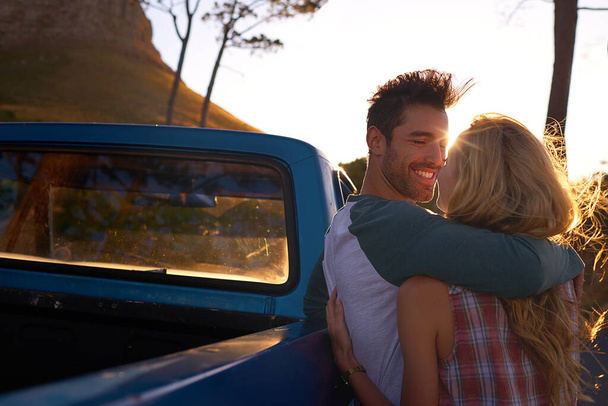 日付にボンディングのためのロマンチックな休日や休暇に自然の中でのロードトリップで抱擁、車や幸せなカップル。トラック、旅行や人々は一緒に公園でロマンスと夏の週末の旅行に抱擁または抱擁. - 写真・画像