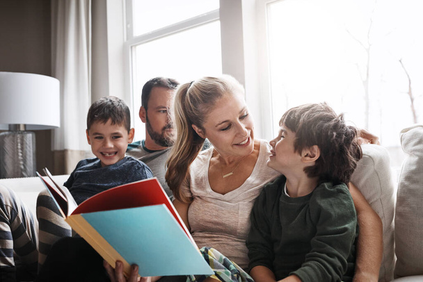 Perhe, lukeminen kirja vanhempien ja lasten kanssa, onnellisuus kotona tarinan aikaa ja oppimista. Rakkaus, suhde ja onnelliset ihmiset liimaus ja hoito olohuoneessa koulutuksen ja kehityksen. - Valokuva, kuva