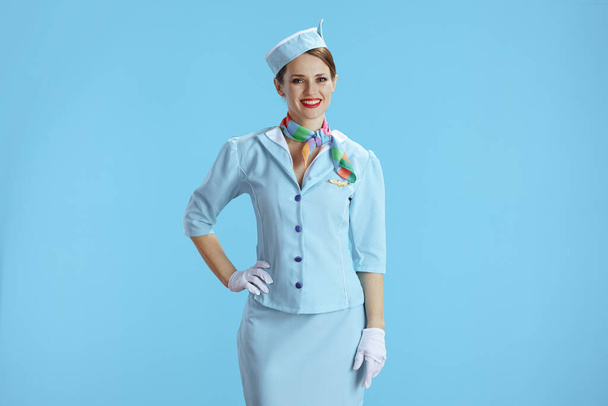 happy stylish female stewardess isolated on blue background in blue uniform. - Fotoğraf, Görsel